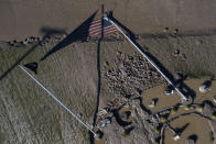 A water-logged flag lies in the mud, Thursday, May 21, 2020, in Sanford, Mich. A Sanford resident picked the flag up after this photo was taken and respectfully dropped it over its pole. (Neil Blake/The Grand Rapids Press via AP)