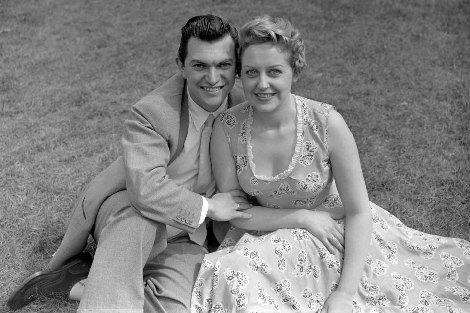 (L-R) Composer Monty Norman and his fiancee, singer Diana Coupland (Photo by Barratts/PA Images via Getty Images)