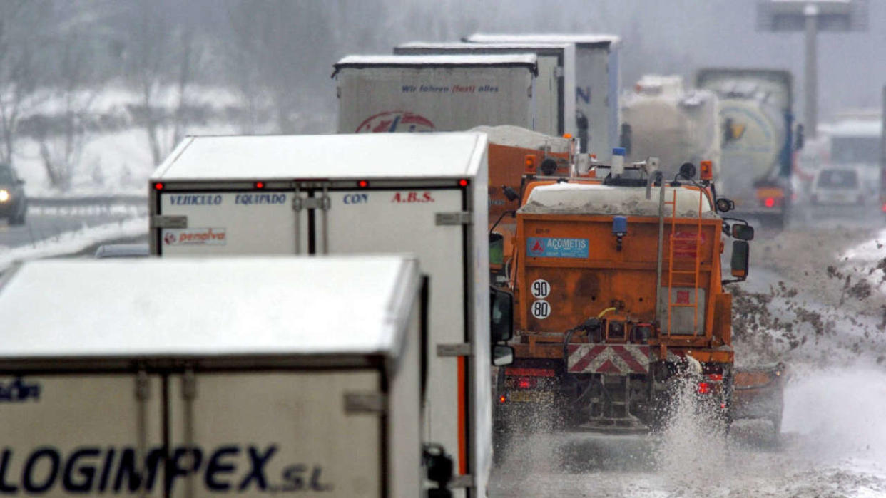 Snowploughs clear the road covered with snow as trucks and cars drive slowly, 28 December 2005 between Toul and Nancy, eastern France. Thousands of people were stranded in their cars or forced to camp in roadside shelters overnight, as heavy snowfall blanketed much of eastern and northwestern France, authorities said today. (Photo by ILAN GARZONE / AFP) (Photo by ILAN GARZONE/AFP via Getty Images)