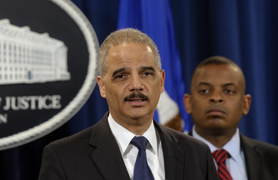 Attorney General Eric Holder, left, accompanied byTransportation Secretary Anthony Foxx, announces a $1.2 billion settlement with Toyota over its disclosure of safety problems, Wednesday, March 19, 2014, during a news conference at the Justice Department in Washington. (AP Photo/Susan Walsh)