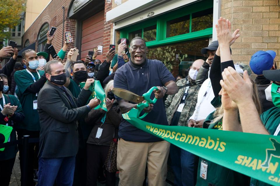FILE - Shawn Kemp, center, a former NBA basketball player for the Seattle SuperSonics and several other teams, reacts after he cut the grand-opening ribbon for Shawn Kemp's Cannabis, the marijuana dispensary he owns with several business partners, Friday, Oct. 30, 2020, in downtown Seattle. Shawn Kemp was arrested and charged in connection with a drive-by shooting in Tacoma, Washington, and was set to be appear in court Thursday, March 9, 2023, a sheriff's official said. Online jail records show Kemp was booked on a felony charge of drive-by shooting shortly before 6 p.m. Wednesday. (AP Photo/Ted S. Warren, File)
