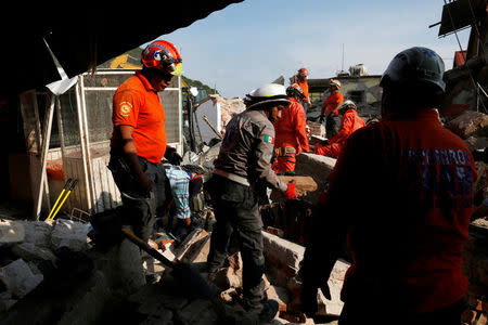 Rescue workers known as Topos Azteca clear the debris of a building damaged in an earthquake that struck the southern coast of Mexico late on Thursday, in Juchitan, Mexico, September 9, 2017. REUTERS/Carlos Jasso