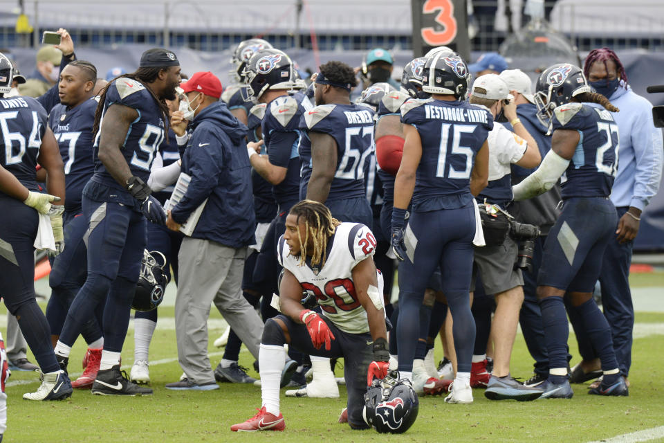 Houston Texans strong safety Justin Reid (20) kneels on the field as Tennessee Titans players celebrate after the Titans won 42-36 in overtime at an NFL football game Sunday, Oct. 18, 2020, in Nashville, Tenn. (AP Photo/Mark Zaleski)