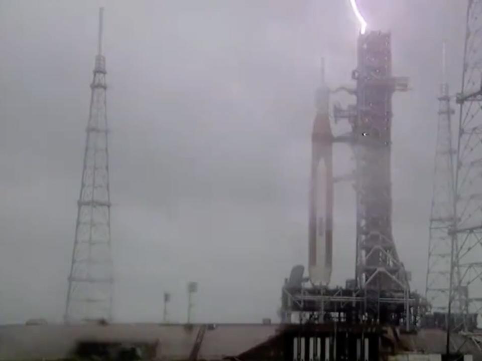 A still of a livestream shows lightning hitting the tower supporting NASA's new SLS rocket.