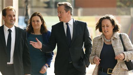 Britain's Prime Minister David Cameron (2R) arrives at his hotel with party workers and members on the opening day of the Conservative Party annual conference in Manchester, northern England September 29, 2013. REUTERS/Phil Noble