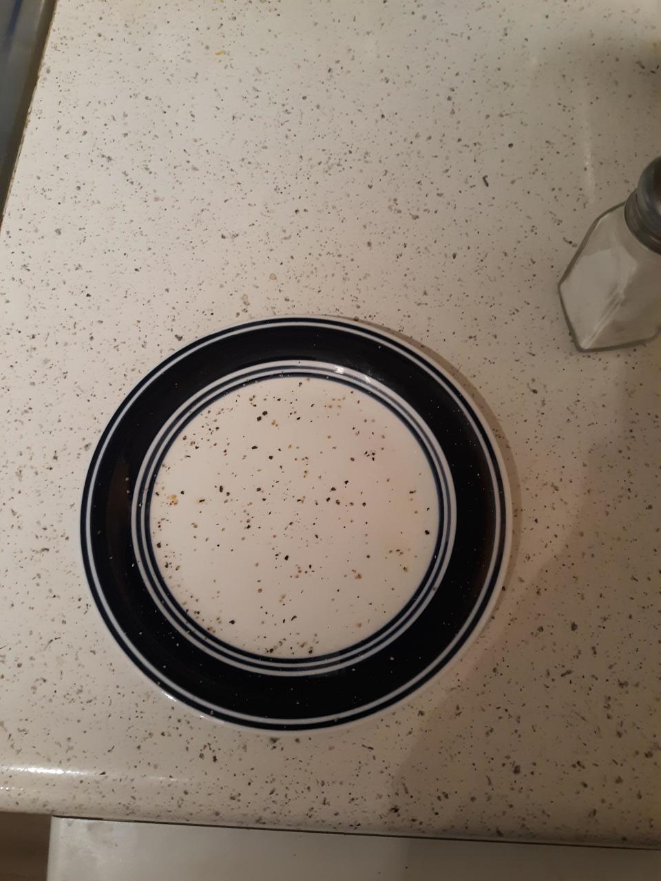 a plate with pepper and other seasonings on it that match the countertop perfectly