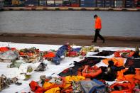 An Indonesian Search and Rescue personnel walks past debris of the Sriwijaya Air flight SJ 182 which crashed into Java sea, at Tanjung Priok port in Jakarta