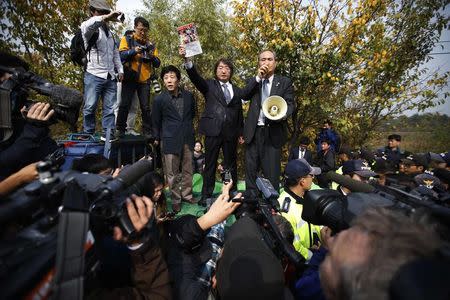 A member of an anti-North Korean civic group holds up a leaflet condemning North Korean dictatorship as they speak to the media near the demilitarized zone separating the two Koreas, in Paju October 25, 2014. REUTERS/Kim Hong-Ji