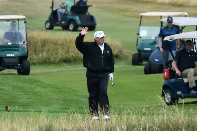 US President Donald Trump waves during a round of golf on his course at Trump Turnberry, a luxury golf resort in southwest Scotland