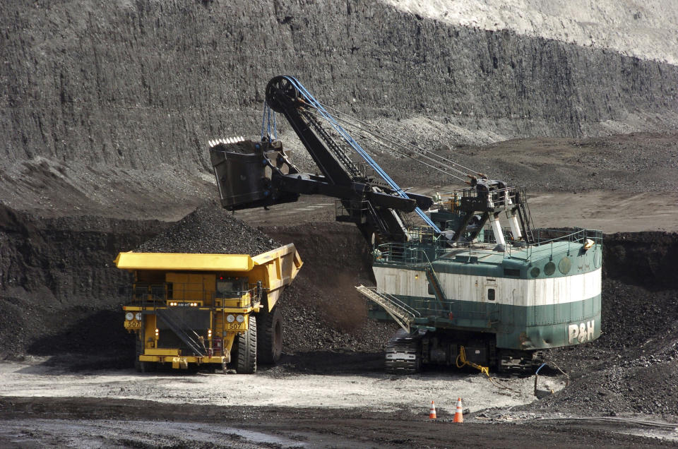 FILE - In this April 4, 2013, file photo, a mechanized shovel loads a haul truck that can carry up to 250 tons of coal at the Spring Creek coal mine near Decker, Mont. Federal officials say the Trump administration's decision to lift a moratorium on coal sales from public lands could hasten the release of more than 5 billion tons of greenhouse gasses. The report comes after a court ruled last month that the administration failed to consider the environmental effects of its resumption in 2017 of coal sales. A moratorium had been imposed under President Barack Obama over worries about climate change. (AP Photo/Matthew Brown, File)