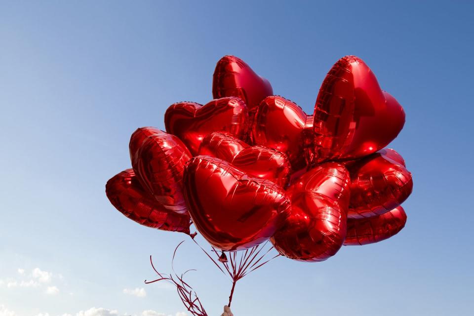 a bunch of red heart shaped balloons