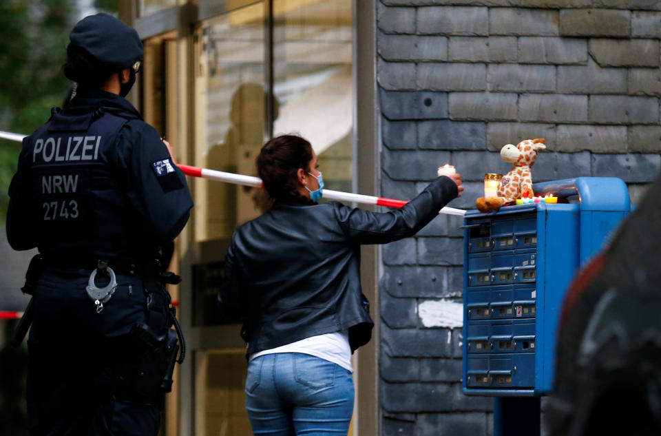 Eine Frau zündet am Hauseingang eine Kerze für die toten Kinder an (Bild: Reuters/Thilo Schmuelgen)