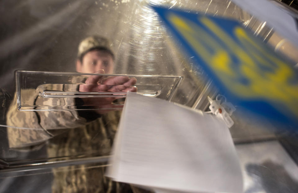 An Ukrainian government soldier casts his ballot in a tent using as a polling station during the president elections in Kurakhove, near a contact line not far from Donetsk, eastern Ukraine, Sunday, March 31, 2019. Ukrainians choose from among 39 candidates for a president they hope can guide the country of more than 42 million out of troubles including endemic corruption, a seemingly intractable conflict with Russia-backed separatists in the country's east and a struggling economy. (AP Photo/Evgeniy Maloletka)