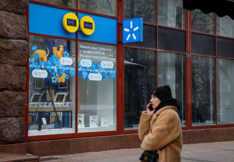 Woman talks on the phone in front of Kyivstar store in Kyiv