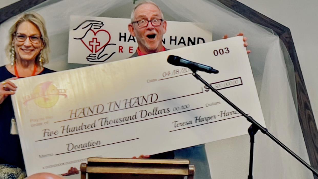 Teresa Harper-Harris of the Harper Family Charitable Foundation presents Hand in Hand Recovery Director David Douglas with a $500,000 toward the organization's "Road to Recovery" program.