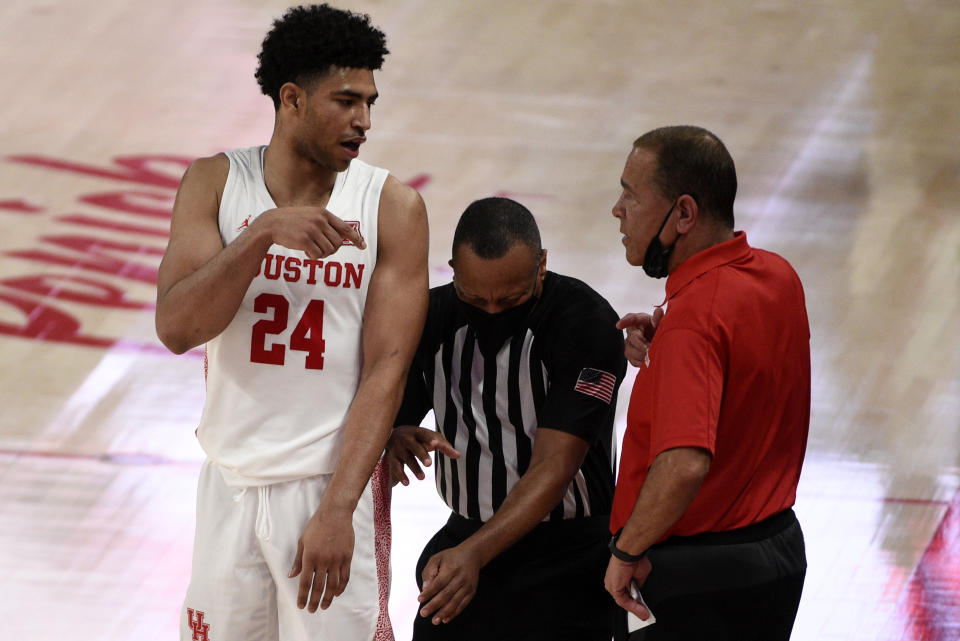 Houston head coach Kelvin Sampson, right, talks with guard Quentin Grimes (24) as an official, center, gets caught in the middle during the second half of an NCAA college basketball game against Cincinnati, Sunday, Feb. 21, 2021, in Houston. (AP Photo/Eric Christian Smith)