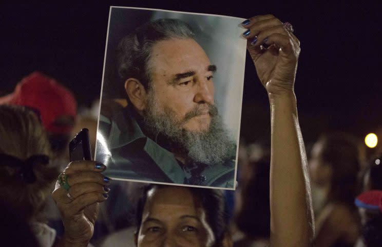 A woman holds a picture of late Fidel Castro during a rally at Revolution Plaza in Havana, Cuba, Tuesday, Nov. 29, 2016. AP Photo/Desmond Boylan