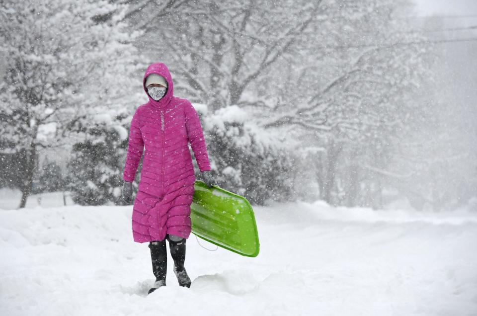 Christina Katen walks along an unplowed West Fourth Street in the Frontier neighborhood in Erie, on Wednesay. The region saw more lake-effect weather overnight Tuesday into Wednesday, with about eight inches of snow on the ground in Erie by midday. The light, fluffy snow was welcomed by Katen, 43, and her son Jude Katen, 6, not pictured. "It's beautiful," said Christina Katen of the light, fluffy snow. It's like living in a snowglobe." Christina Katen was returning home after dropping Jude Katen off at nearby Erie Day School, where he is a kindergartener. Jude got a ride to school from his mom in his sled, which she then had to carry home.