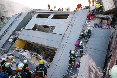 Rescue workers remove people from the site where a 17-storey apartment building collapsed after an earthquake hit Tainan, Taiwan, February 6, 2016. REUTERS/Stringer