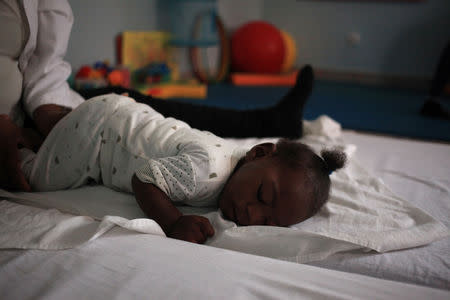 Ten month old Emiliano Cula, who has microcephaly, receives physiotherapy to try and stimulate control over his muscles in Luanda, Angola, September 6, 2018. Picture taken September 6, 2018. REUTERS/Stephen Eisenhammer