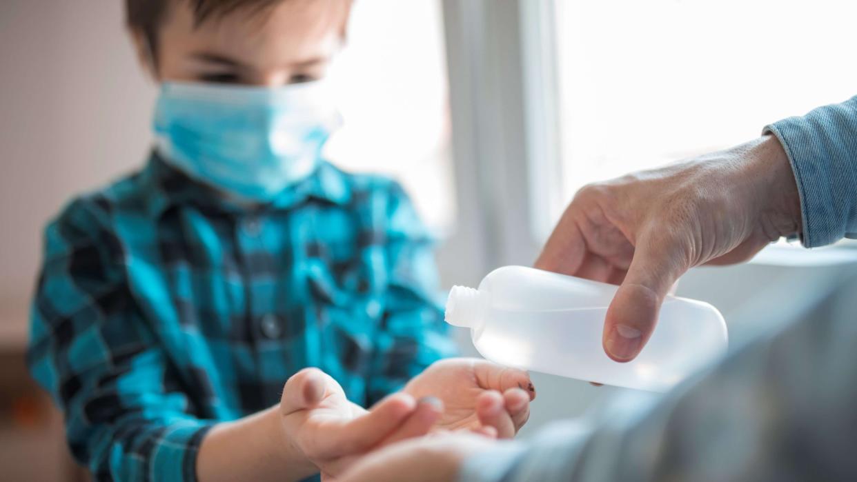 Father and child using sanitize antiseptic for hand coronavirus protection.