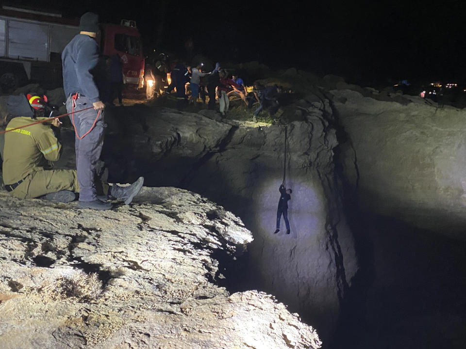 Authorities and local residents save a migrant during a large-scale rescue operation on the island of Kythira, some 225 kilometers (140 miles) south of Athens, early Thursday, Oct. 6, 2022. The operation is underway off a southern Greek island where a sailboat carrying up to 100 migrants sank in high winds. The coast guard said its vessels, private boats and a rescue helicopter were involved in the effort off the coast of the island of Kythira. (Ippolytos Prekas/kythera.news via AP)