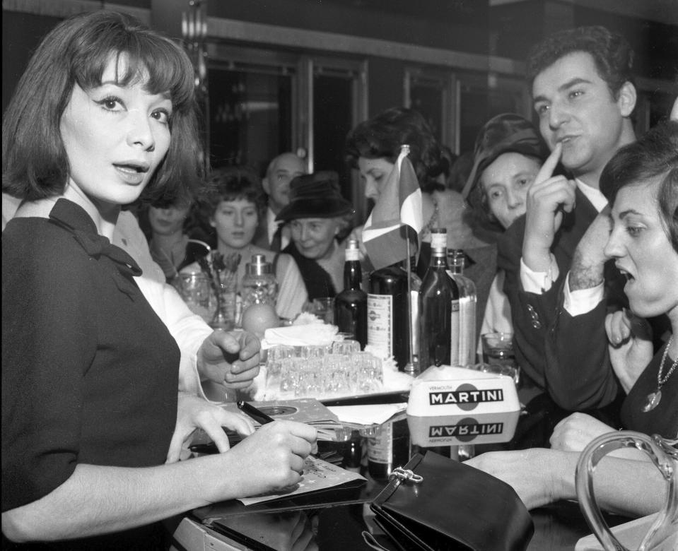 FILE - In this Nov. 8, 1960 file photo, French actress and singer Juliette Greco signs records for her fans during a cocktail party held in her honour in Milan, Italy. French media say Juliette Greco, singer, actress, cultural icon and muse to Existentialist philosophers of France’s post-War period, has died aged 93. They said Wednesday, Sept. 23, 2020 Greco died in her Ramatouelle house in the south of France, near Saint Tropez.. (AP Photo/Raoul Fornezza, file)