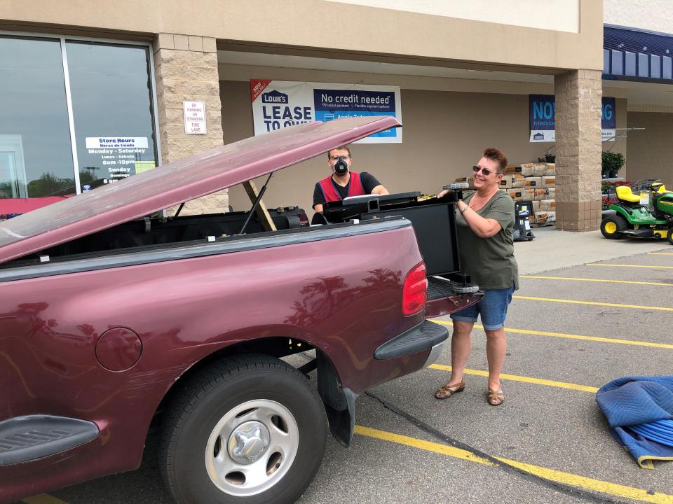 Stephanie McRae uses her husband's 1997 Ford F-150 to pick up a pellet smoker from Lowe's in Fort Gratiot on Sunday for Father's Day. She said her husband would give up cable TV to keep his truck, but not coffee, no way.