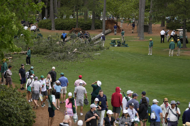 Patrons move away from trees that blew over on the 17th hole during the second round of the Masters golf tournament at Augusta National Golf Club on Friday, April 7, 2023, in Augusta, Ga. Ga. (AP Photo/Matt Slocum)