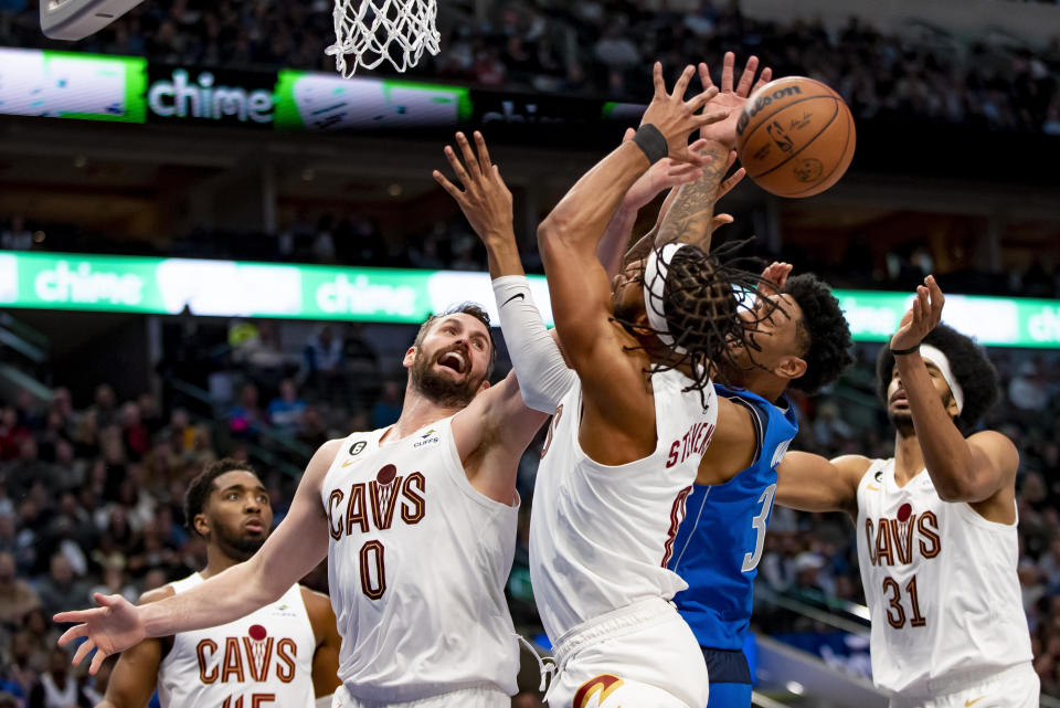 From left, Cleveland Cavaliers forward Kevin Love (0), forward Lamar Stevens (8), Dallas Mavericks forward Christian Wood (35), and Cleveland Cavaliers center Jarrett Allen (31) battle for a rebound in the first half of an NBA basketball game in Dallas, Wednesday, Dec. 14, 2022. (AP Photo/Emil Lippe)