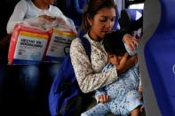 Norymar Torres lleva a su hijo Leonardo Colmenares de seis años en el transporte público. El niño tiene una enfermedad neurológica y es tratado con anticonvulsivos. Caracas, Venezuela. REUTERS/Carlos Garcia Rawlins. 18 de enero de 2017.