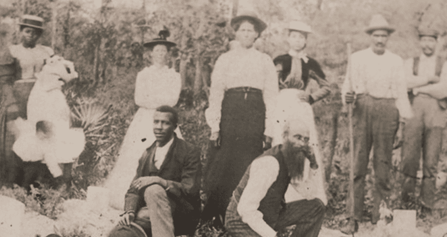 John Henry Monroe (left) and Martine Goins (right) kneel at the funeral of Eli Waldron, Goins' brother-in-law, in 1900 in Rosewood. Behind them stand Sophie Goins Monroe, her mother, and Lydia Goins, the sister of Eli Waldron.