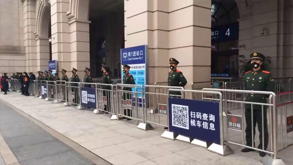 Los policías vigilan la estación de tren de Wuhan (The Paper via AP)