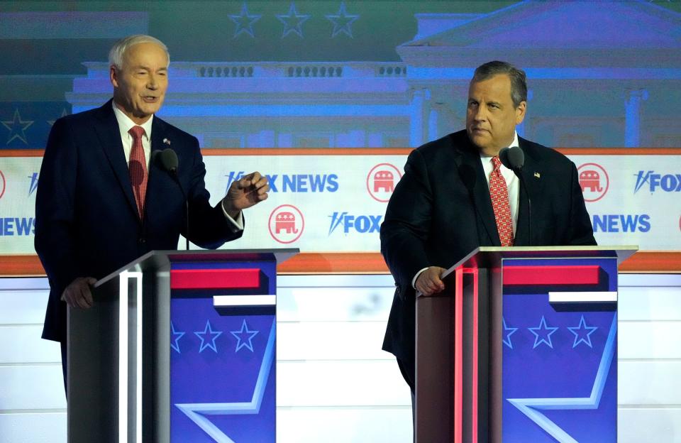 Republican presidential candidate former Arkansas Gov. Asa Hutchinson speaks as Republican presidential candidate former New Jersey governor Chris Christie listens at Fiserv Forum during the first 2023 Republican presidential debate in Milwaukee on Wednesday, Aug. 23, 2023.