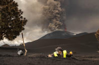 A scientist from IGME-CSIC (Spanish National Research Council) collects samples of volcanic ashes on the Canary island of La Palma, Spain, Thursday, Nov. 18, 2021. Scientists from around the world flocking to an eastern Atlantic Ocean island are using an array of new technologies available to them in 2021 to scrutinize — from land, sea, air, and even space — a rare volcanic eruption. (AP Photo/Taner Orribo)