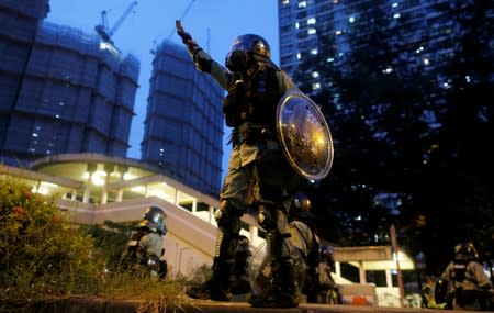 A riot police officer gestures during a demonstration held by anti-extradition bill protesters in Tai Wai in Hong Kong