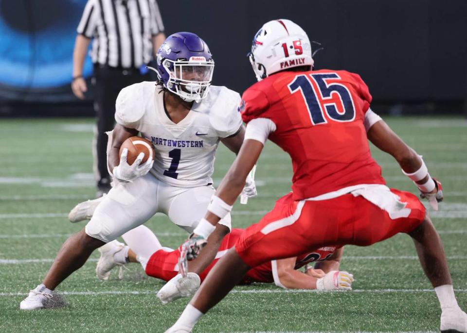 Northwestern’s Turbo Richard carries the ball around Providence Day’s Cairo Skanes on Saturday, Aug. 19, 2023 at Panthers’ Stadium.