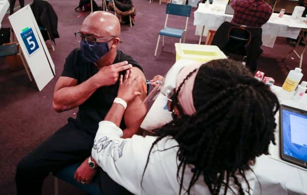 Eugene Anderson received the first dose of his COVID-19 vaccine from nurse Carolyne Aremo on Thursday during the clinic in Upper Hammonds Plains, N.S. (Communications Nova Scotia - image credit)