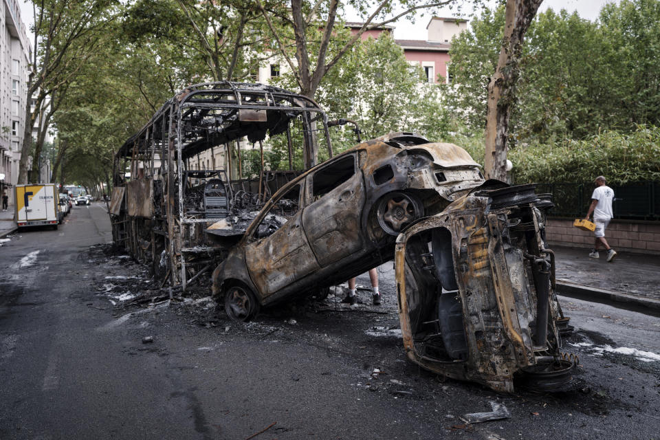 Charred cars and bus are pictured in Lyon, central France, Friday, June 30, 2023. French President Emmanuel Macron urged parents Friday to keep teenagers at home and proposed restrictions on social media to quell rioting spreading across France over the fatal police shooting of a 17-year-old driver that has resulted so far in the arrests of 875 people. (Laurent Cipriani)