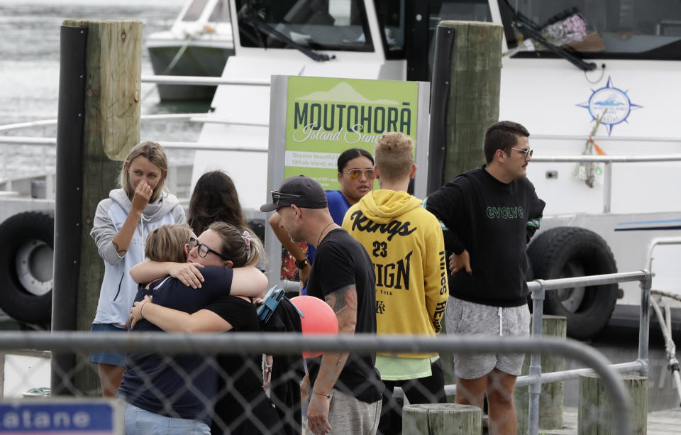 Families of victims of the White Island eruption embrace as they arrive back to the Whakatane wharf following a blessing at sea ahead of the recovery operation off the coast of Whakatane New Zealand, Friday, Dec. 13, 2019. A team of eight New Zealand military specialists landed on White Island early Friday to retrieve the bodies of victims after the Dec. 9 eruption. (AP Photo/Mark Baker)