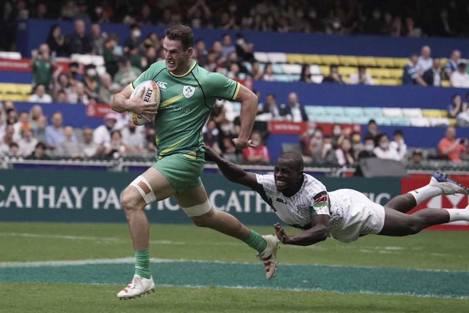 Jack Kelly of Ireland runs to score a try as Daniel Taabu of Kenya attempts to tackle him during the first day of the Hong Kong Sevens rugby tournament in Hong Kong, Friday Nov. 4, 2022. The Hong Kong Sevens, a popular stop on the World Rugby Sevens Series circuit, is part of the government's drive to restore the city's image as a vibrant financial hub after it scrapped mandatory hotel quarantine for travelers. (AP Photo/Anthony Kwan)
