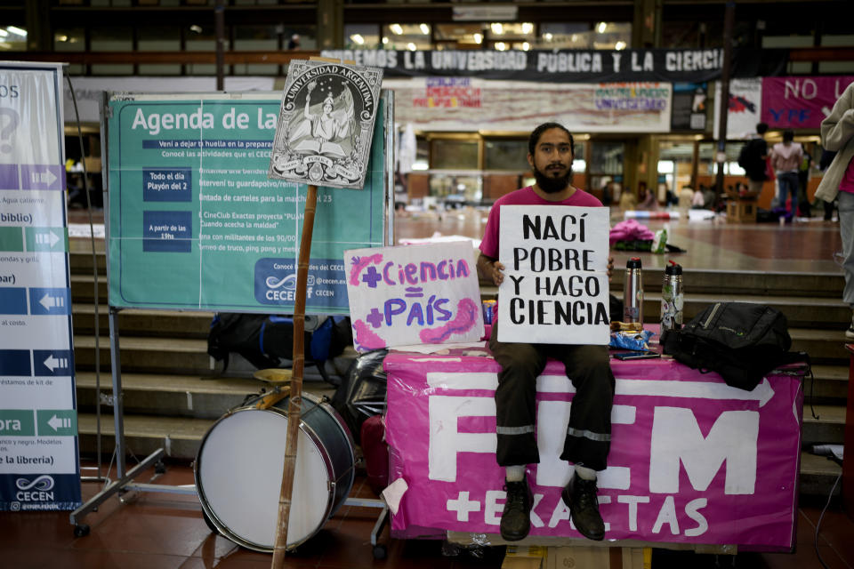 El estudiante de biología Bahiano Ayala sostiene un cartel que reza "Nací pobre y hago ciencia" mientras espera el inicio de una marcha para exigir más fondos para las universidades públicas en Buenos Aires, Argentina, el martes 23 de abril de 2024. (AP Foto/Natacha Pisarenko)