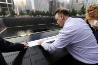 Ron Joy makes a rubbing of his friend's name, New York City Firefighter Capt. Vincent Giammona on the wall of names at the South reflecting pool at the 9/11 Memorial during ceremonies marking the 12th anniversary of the 9/11 attacks on the World Trade Center in New York, September 11, 2013. (REUTERS/Stan Honda)