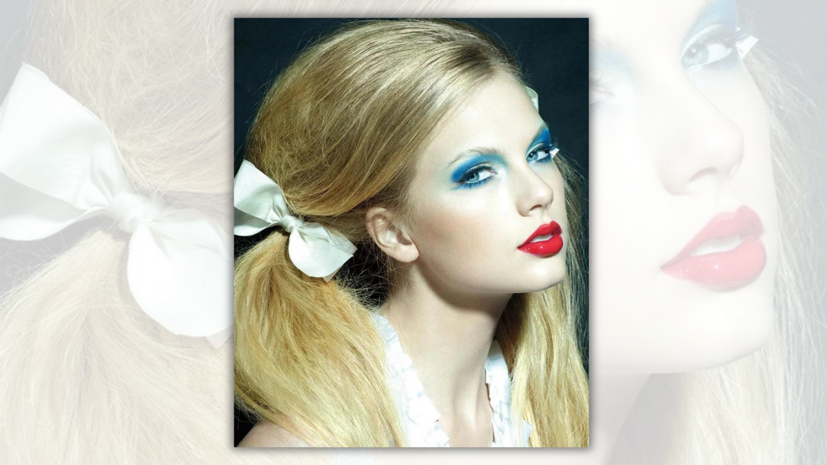 A white woman wearing red lipstick and blue eyeshadow looks towards the camera. On the side of her head towards the camera, she has her hair pulled into a pigtail with a white bow. 