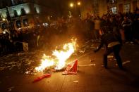 A protester burns a General Workers Union (UGT) flag during a protest at Madrid's Puerta del Sol square November 4, 2013. Spain's labor unions called for an indefinite strike from Tuesday in Spain's capital for the street cleaning and park maintenance sectors in protest against announced layoffs that could affect around a thousand municipal workers, according to local media. (REUTERS/Juan Medina)