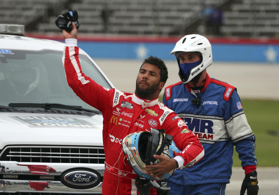 Bubba Wallace tosses his gloves while walking away from his damaged car during the NASCAR Cup Series auto race at Texas Motor Speedway in Fort Worth, Texas, Wednesday, Oct. 28, 2020. (AP Photo/Richard W. Rodriguez)