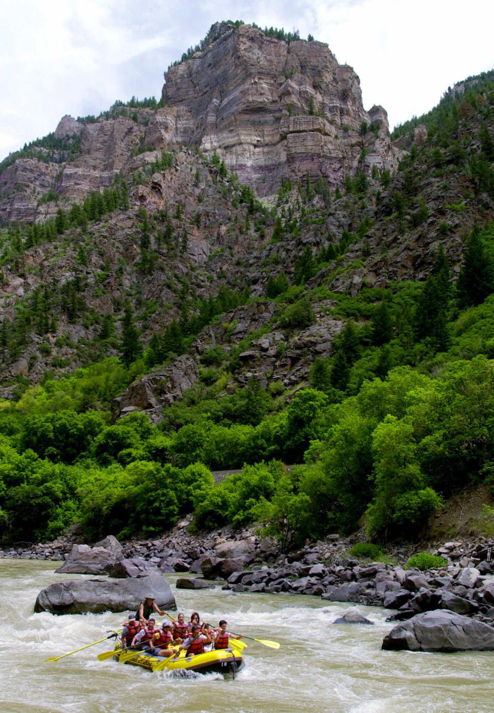 FILE -- In this July 12, 2001, file photo, rafters ride the white waters of the Colorado River during a rafting trip in Glenwood Canyon near Glenwood Springs, Colo. After a winter of historically low snowpack combined with an earlier-than-normal runoff, Colorado river guides and tourists are adjusting their spring and summer plans for what is turning out to be an early paddling season. (AP Photo/Ed Andrieski, File)