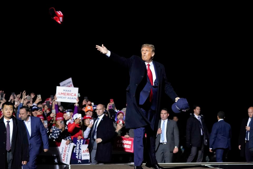 President Donald Trump throws hats to supporters after speaking at a campaign rally Sept. 30 at Duluth International Airport in Minnesota. The president and first lady Melania Trump tested positive for the coronavirus.