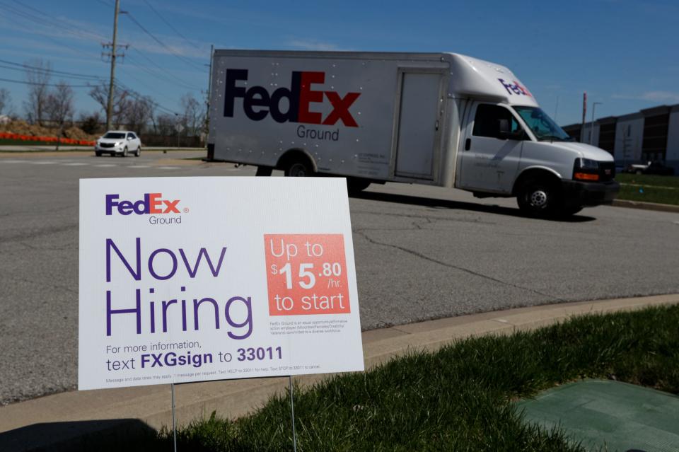 A sign advertising for jobs sits along the roadside outside a FedEx location in Zionsville, Ind., on April 2, 2020.