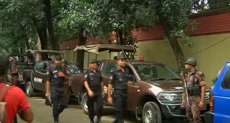 Rapid Action Battalion members walk as police stormed the Holey Artisan restaurant after gunmen attacked it and took hostages early on Saturday in Dhaka, Bangladesh in this still frame taken from live video July 2, 2016. REUTERS/ REUTERS TV